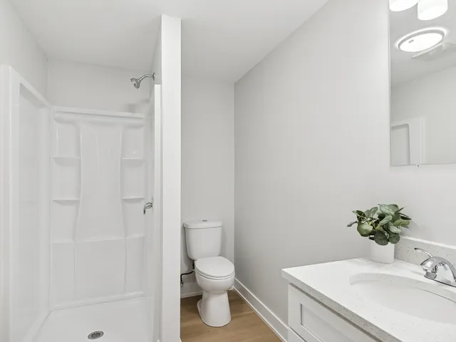 a bathroom with a granite countertop sink toilet and shower