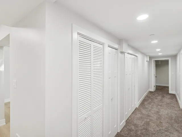 a view of a hallway with wooden floor and closet