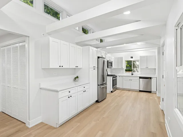 a kitchen with white cabinets and white appliances