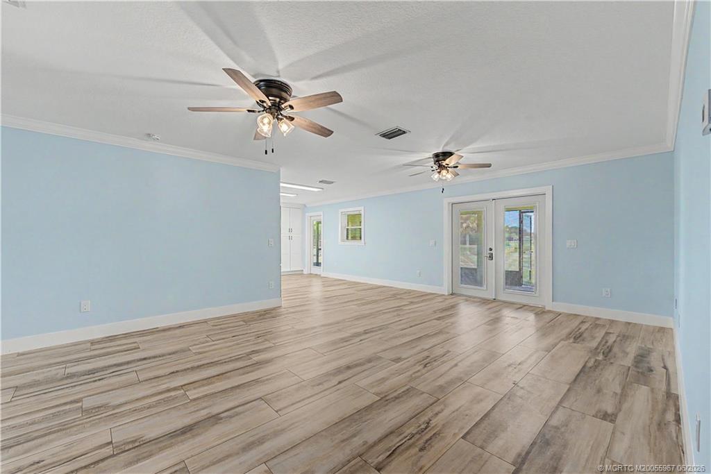 8200 Southwest Springhaven Avenue Indiantown, FL 34956 - Photo 21 of 35 wooden floor in an empty room with a window