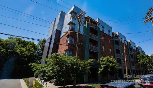 a view of a tall building next to a yard
