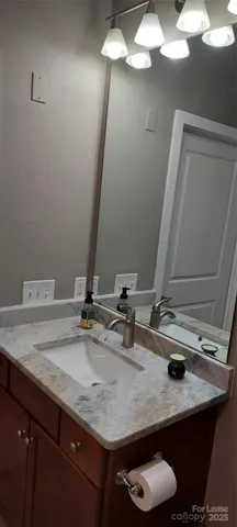 a bathroom with a sink vanity mirror and toilet