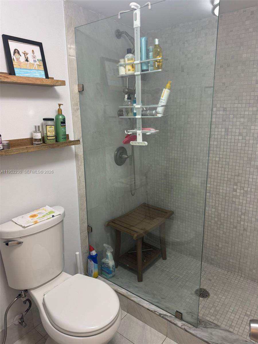 8810 Southwest 123rd Court, Unit M202 Miami, FL 33186 - Photo 20 of 34 a bathroom with a toilet a sink and shower