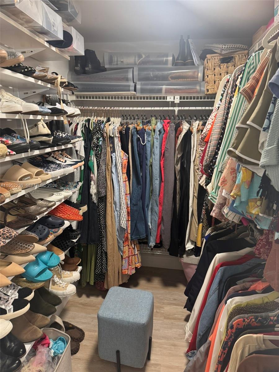 8810 Southwest 123rd Court, Unit M202 Miami, FL 33186 - Photo 22 of 34 a view of walk in closet with clothes and shoes