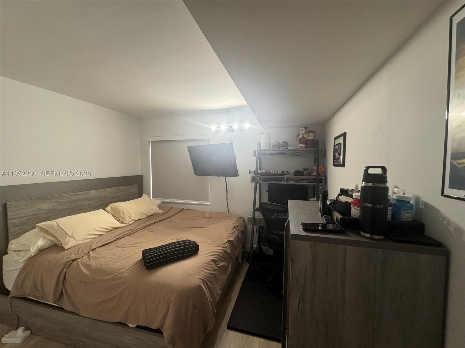 8810 Southwest 123rd Court, Unit M202 Miami, FL 33186 - Photo 26 of 34 a bed sitting in a bedroom and night stand