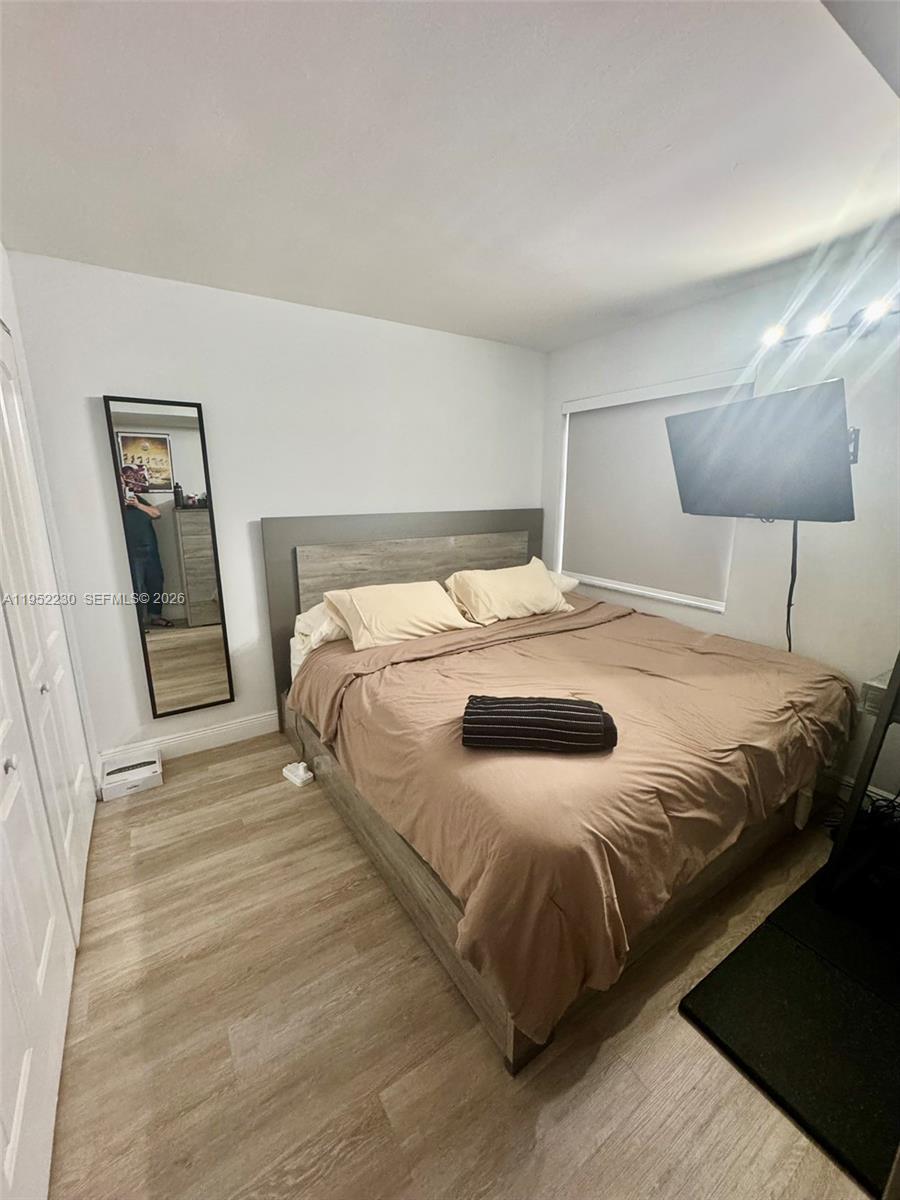 8810 Southwest 123rd Court, Unit M202 Miami, FL 33186 - Photo 27 of 34 a bedroom with a bed and a lamp