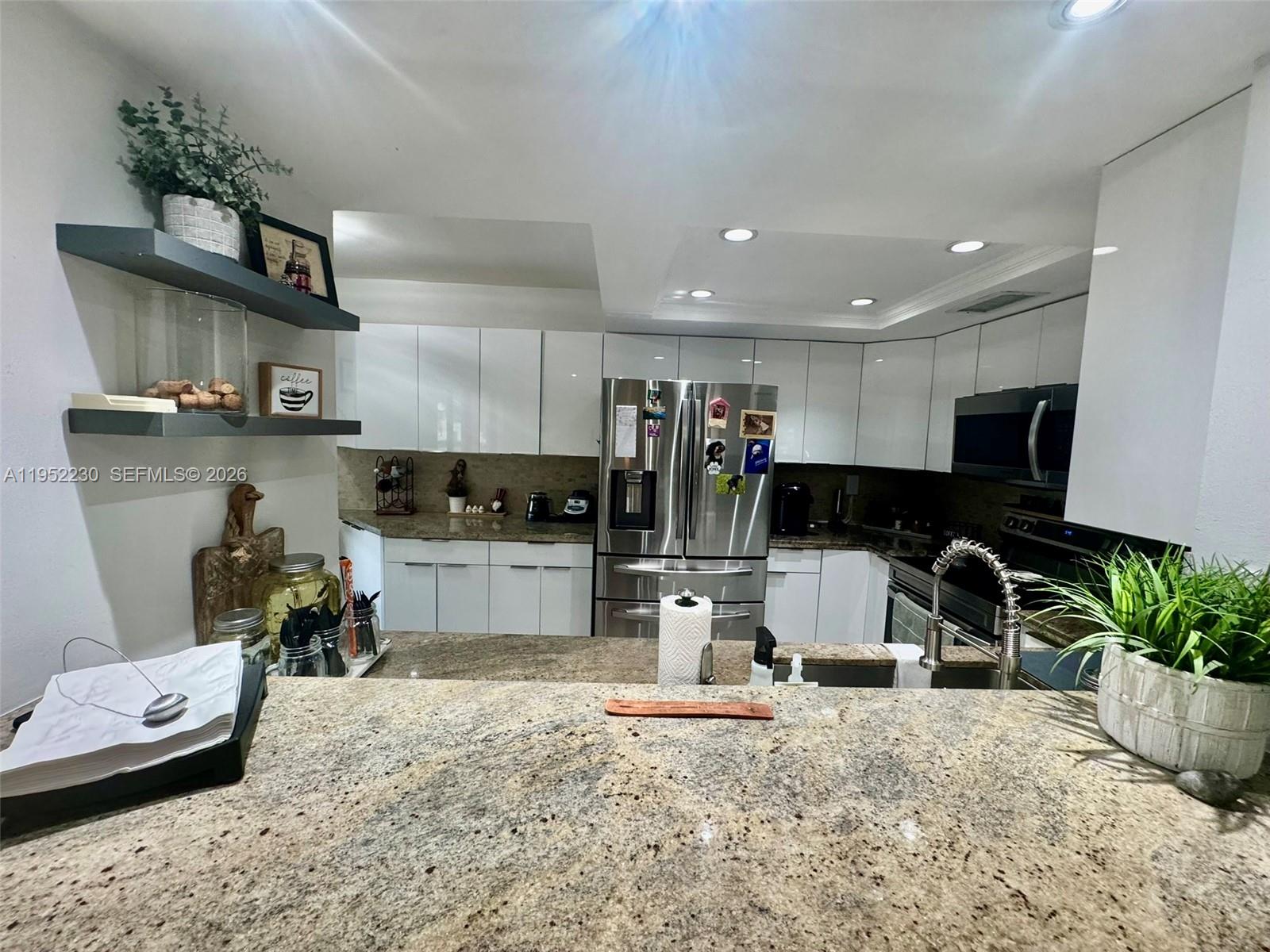 8810 Southwest 123rd Court, Unit M202 Miami, FL 33186 - Photo 8 of 34 a kitchen with stainless steel appliances kitchen island granite countertop a sink and cabinets