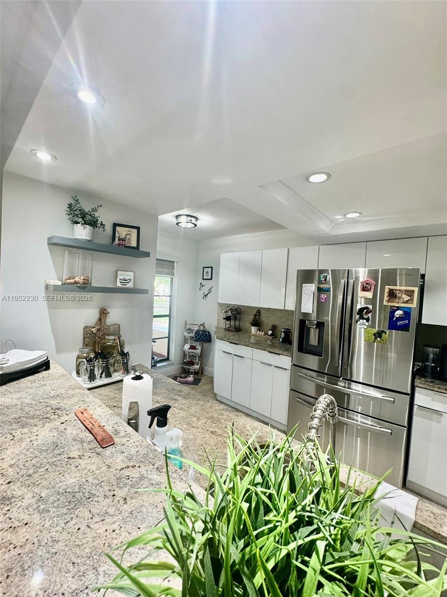8810 Southwest 123rd Court, Unit M202 Miami, FL 33186 - Photo 9 of 34 a kitchen with stainless steel appliances kitchen island granite countertop a sink and cabinets