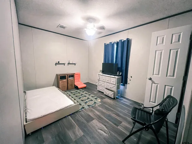 a bedroom with a bed and wooden floor