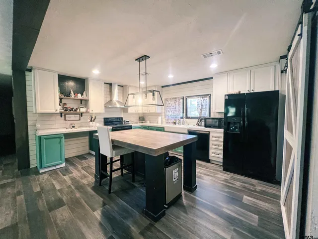 a kitchen with a refrigerator a sink dishwasher and a stove with wooden floor