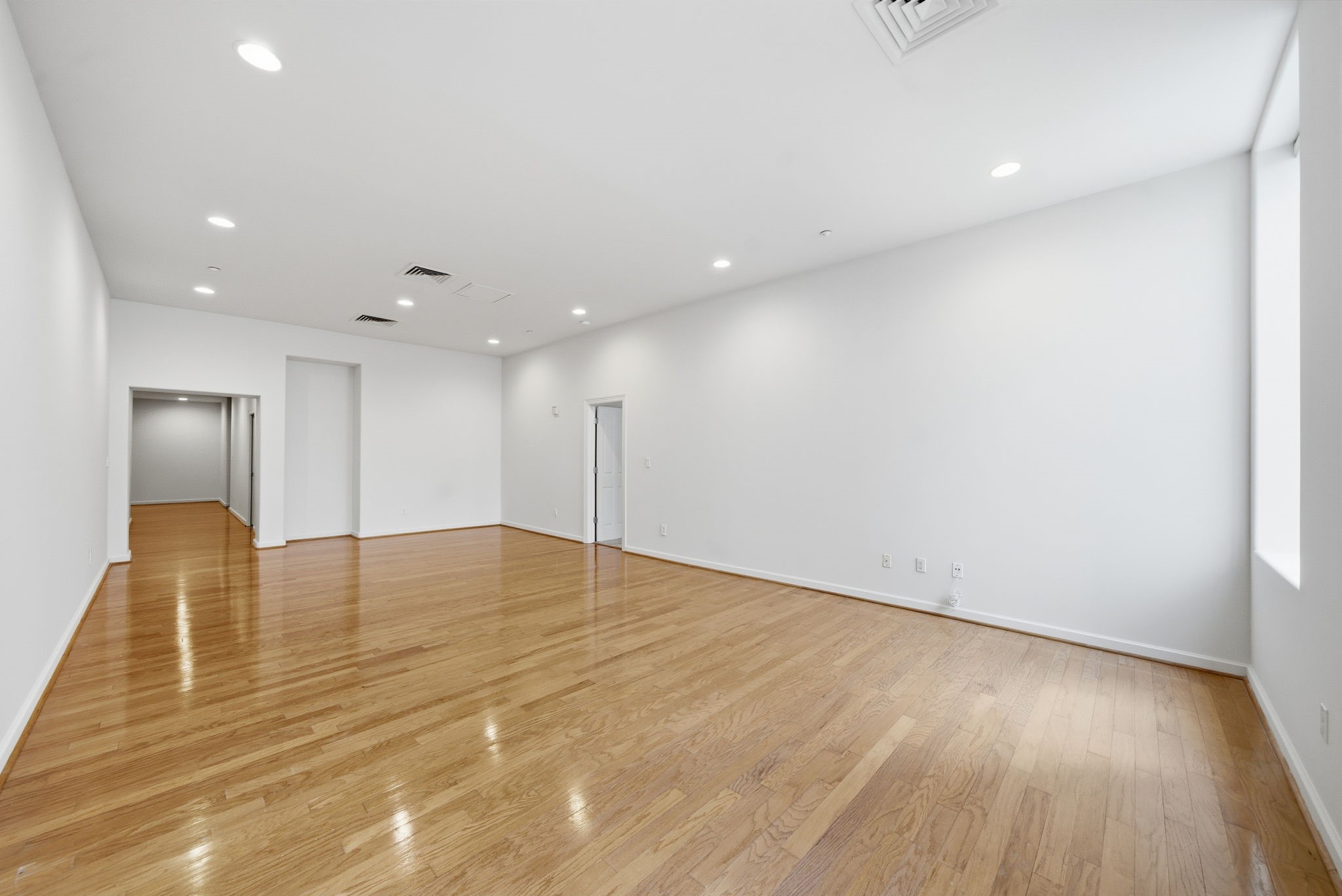 914 Main Street, Unit 704 Houston, TX 77002 - Photo 3 of 22 an empty room with wooden floor and natural light