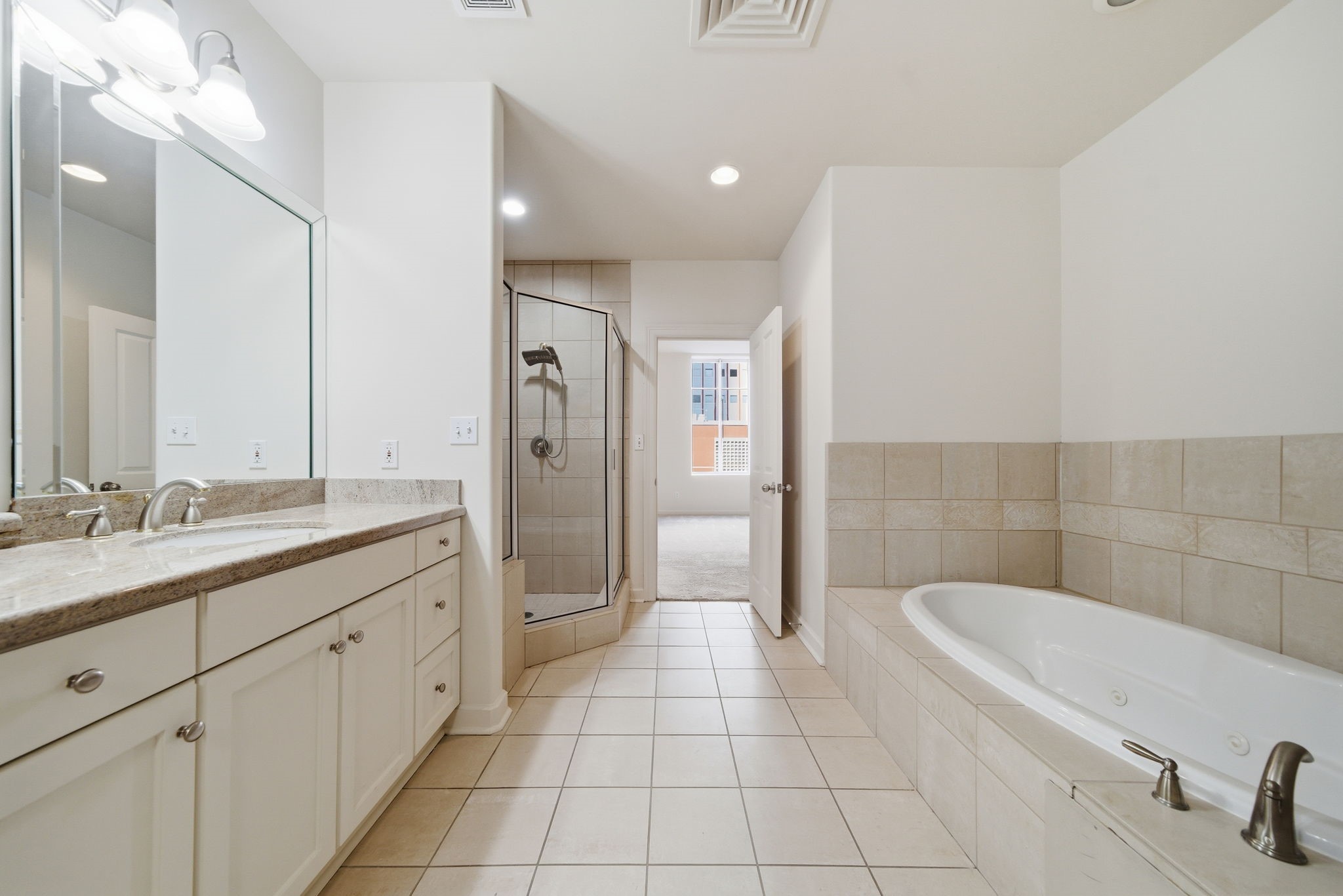 914 Main Street, Unit 704 Houston, TX 77002 - Photo 7 of 22 a bathroom with a granite countertop sink a toilet a mirror and shower