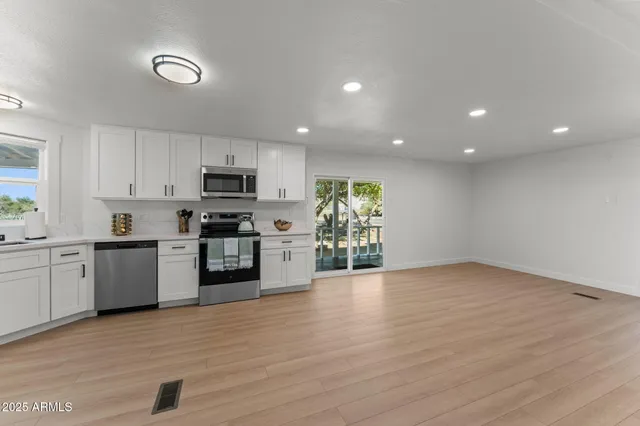 a kitchen with granite countertop a stove top oven and cabinets