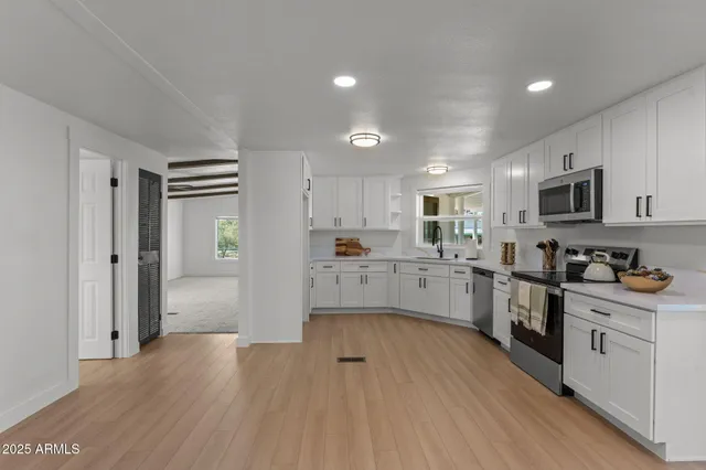 a kitchen with white cabinets and stainless steel appliances