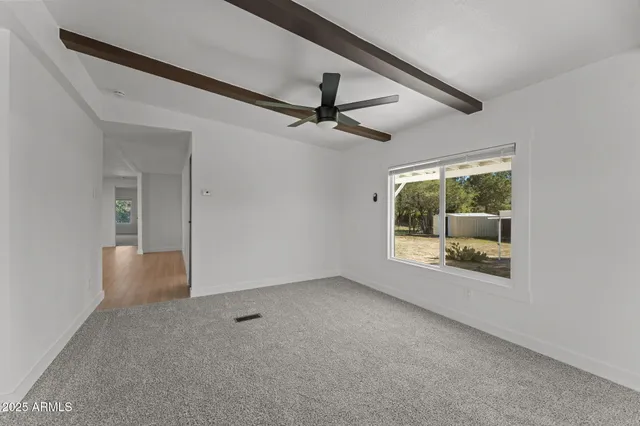 an empty room with windows and fan