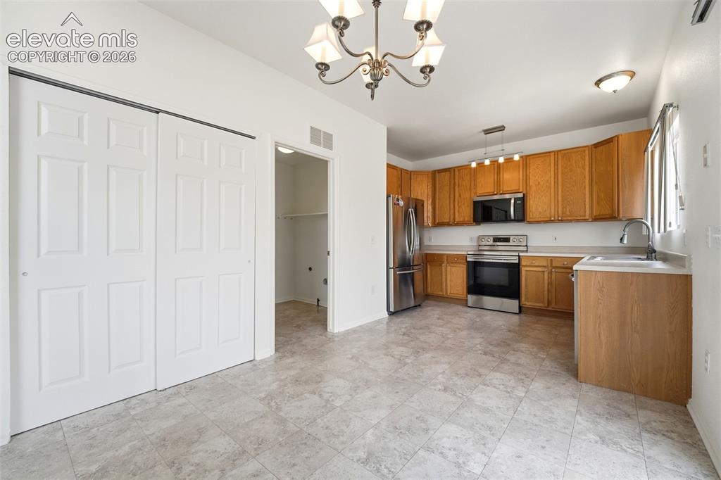 7904 Coffee Road Peyton, CO 80831 - Photo 15 of 48 Kitchen area featuring wood-finish cabinetry and stainless steel appliances