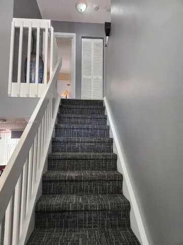 a bedroom with a bed and a flat tv screen on dresser