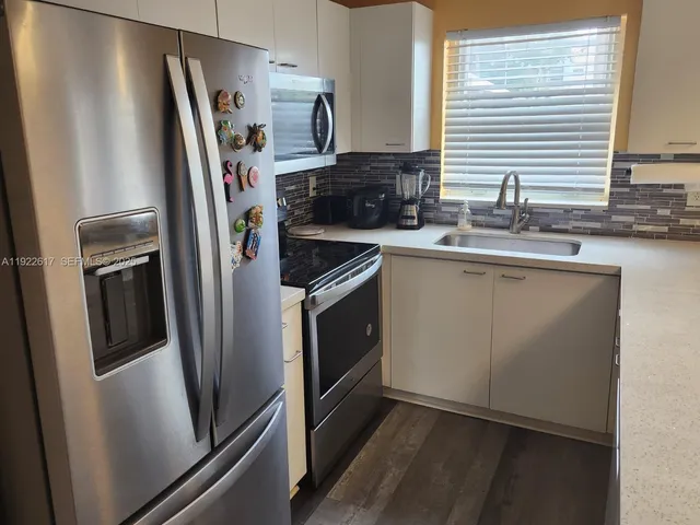 a kitchen with stainless steel appliances a refrigerator sink and microwave