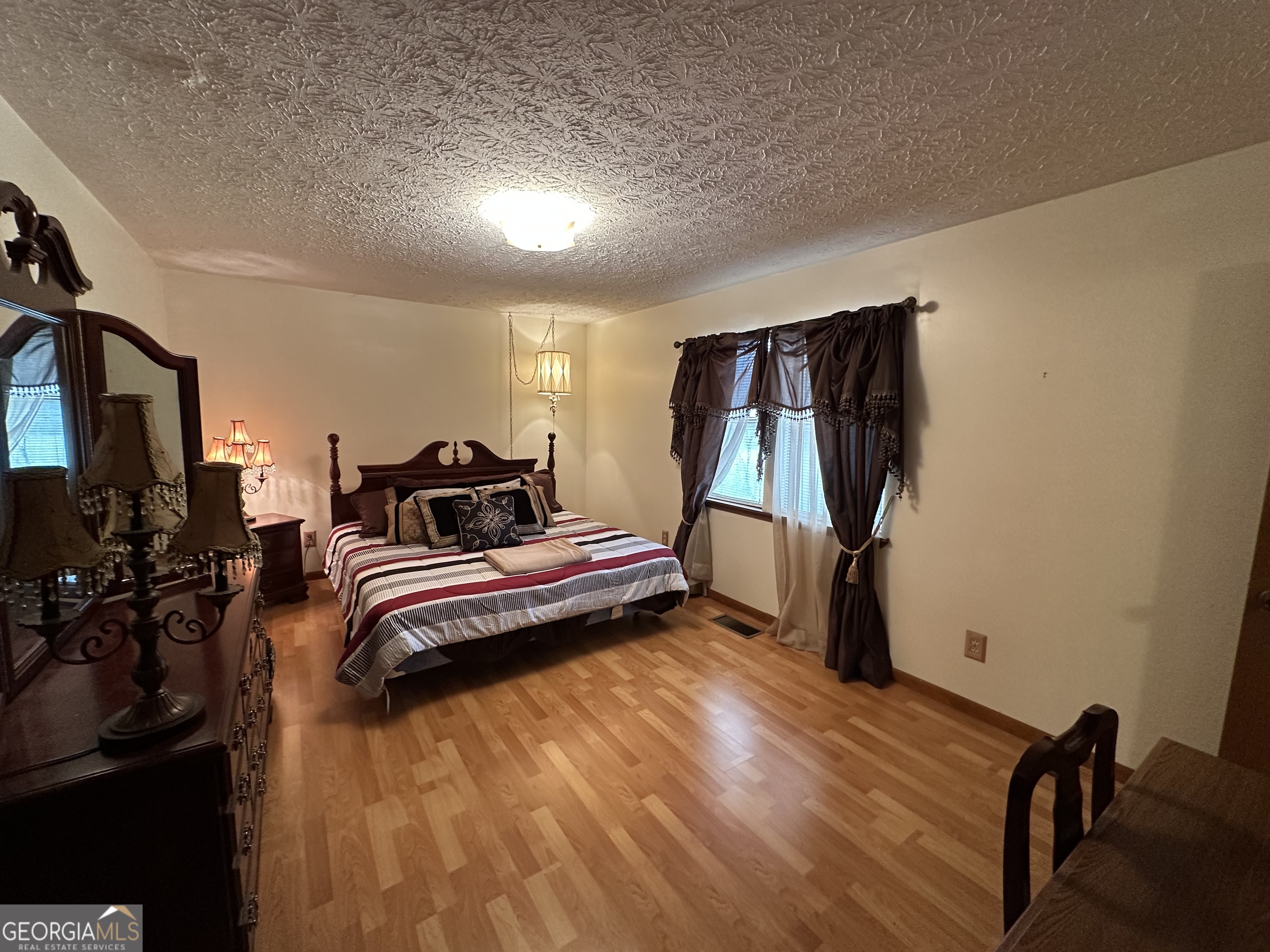 11306 Panhandle Road Hampton, GA 30228 - Photo 15 of 20 a bedroom with a bed and wooden floor