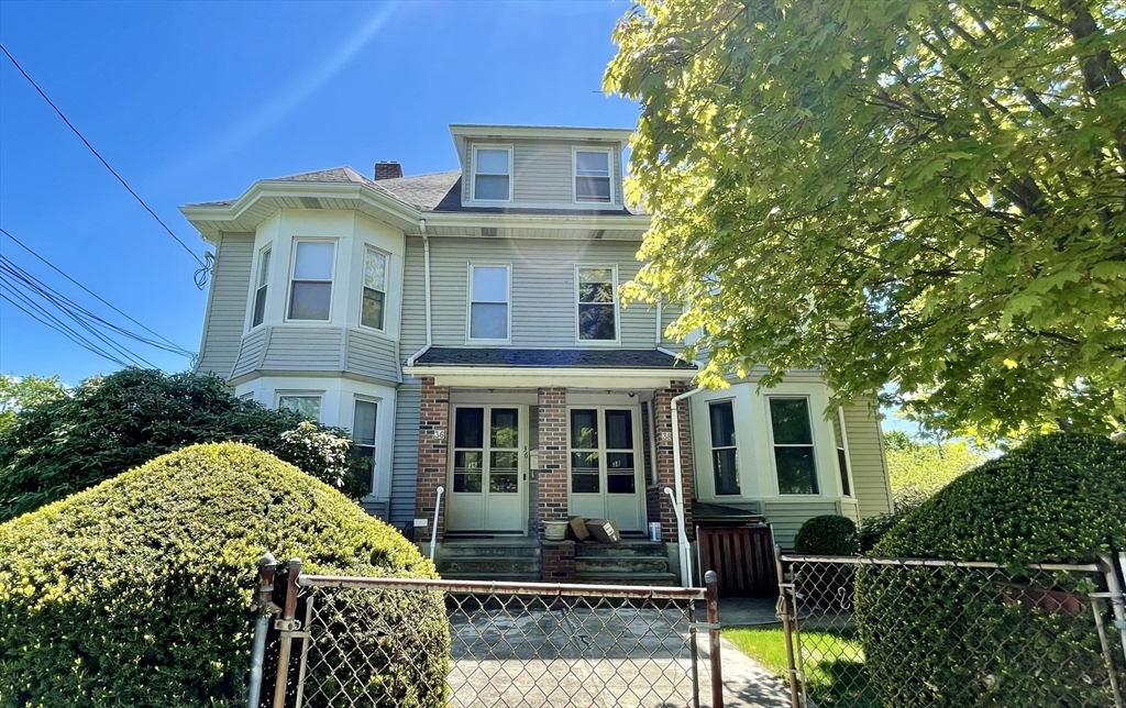 36-2 Lowell Avenue, Unit 362 Newton, MA 02460 - Photo 1 of 22 a view of a white house with large windows and a small yard