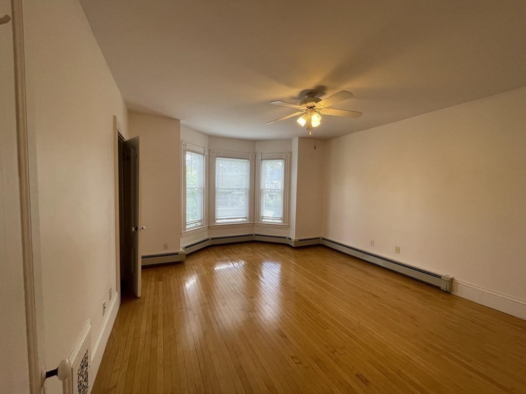 36-2 Lowell Avenue, Unit 362 Newton, MA 02460 - Photo 12 of 22 wooden floor in an empty room with a window