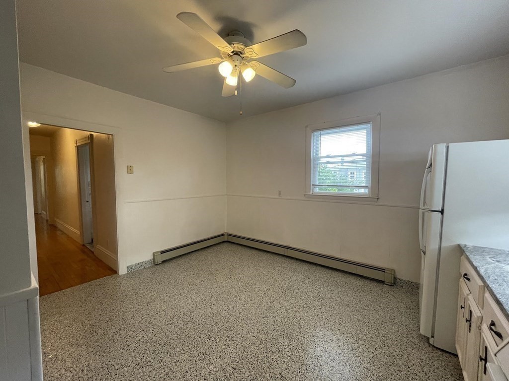 36-2 Lowell Avenue, Unit 362 Newton, MA 02460 - Photo 7 of 22 an empty room with a chandelier fan and windows