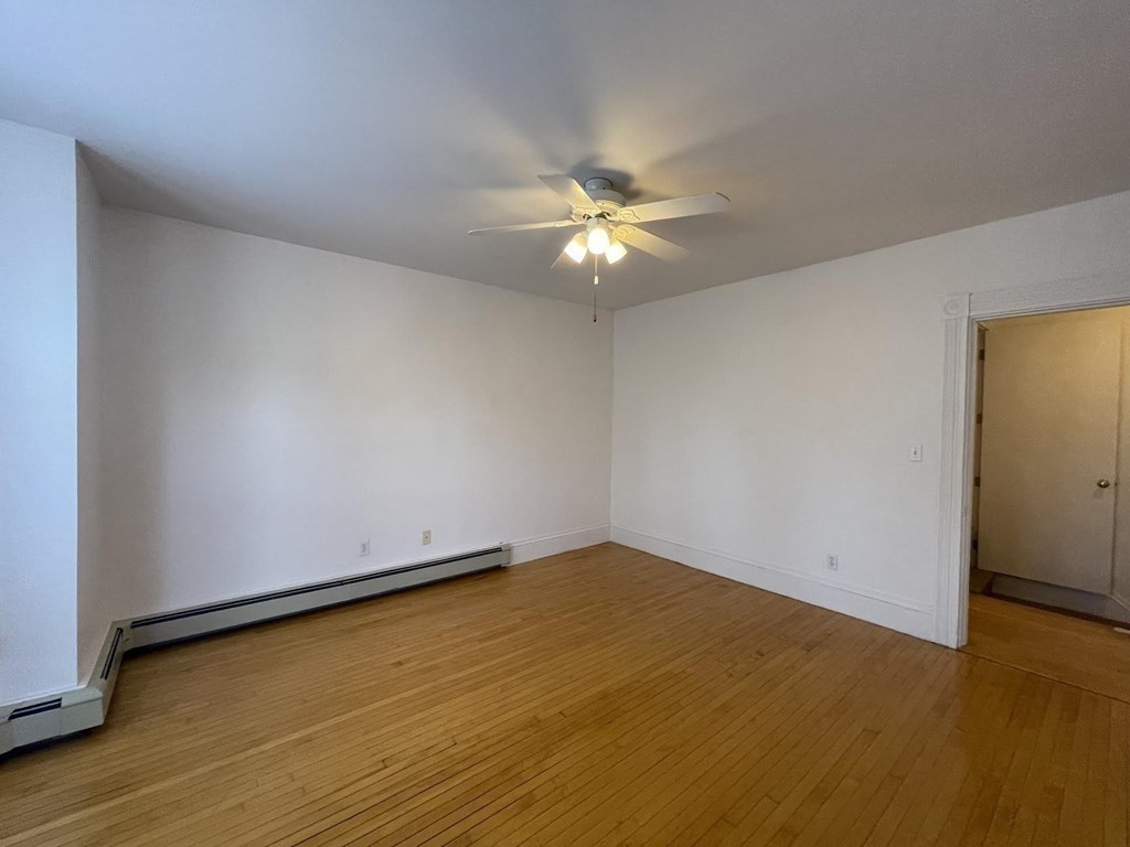 36-2 Lowell Avenue, Unit 362 Newton, MA 02460 - Photo 9 of 22 an empty room with a ceiling fan and wooden floor