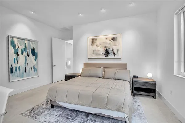 a bedroom with a bed and a painting on the wall