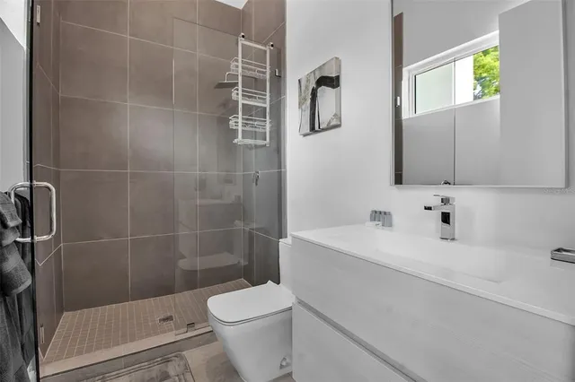 a bathroom with a sink a toilet and shower