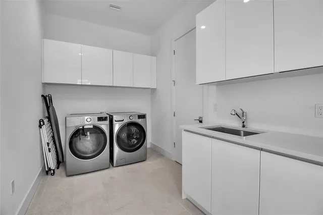 a utility room with sink dryer and washer