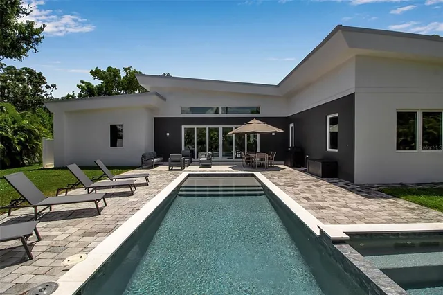 a view of a house with swimming pool and sitting area