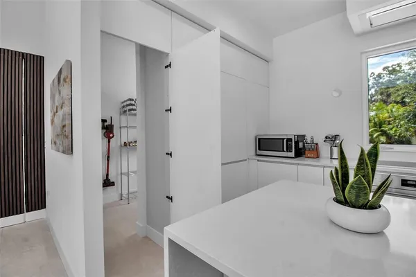 a kitchen with stainless steel appliances a refrigerator and a potted plant