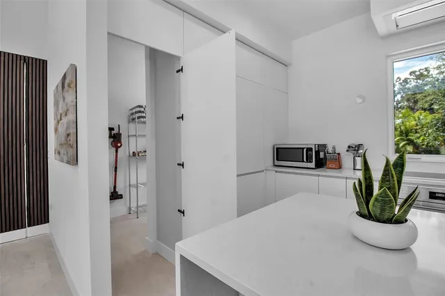 a kitchen with stainless steel appliances a refrigerator and a potted plant