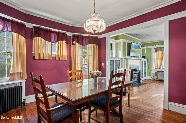 a dining room with furniture a chandelier and wooden floor