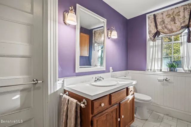 a bathroom with a sink a toilet and a mirror