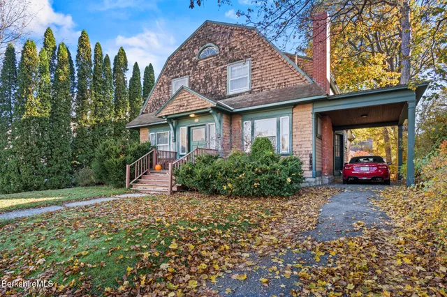 a view of a house with a backyard and trees