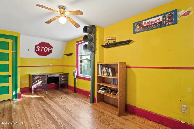 a living room with a bed furniture and a flat screen tv
