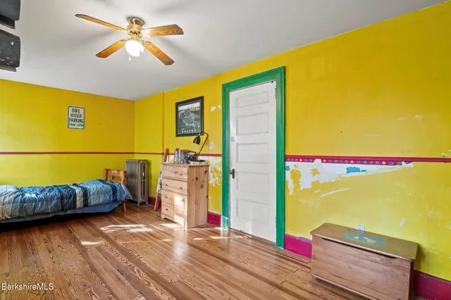 a bed sitting in a spacious bedroom next to a window