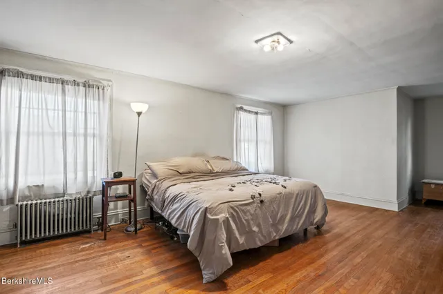 a spacious bedroom with a bed and a window