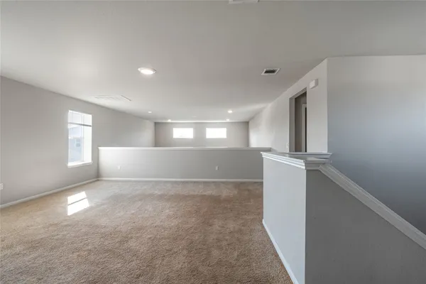 a view of hallway with window and a refrigerator