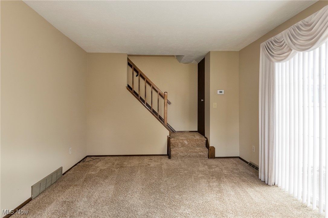 6533 Engle Road Brook Park, OH 44142 - Photo 6 of 38 Living room with patio door to patio, carpet, and stairway to upstairs.