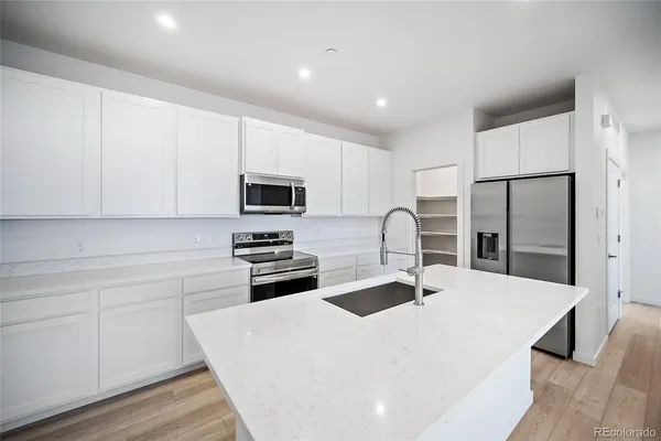 a kitchen with stainless steel appliances a stove refrigerator sink and cabinets