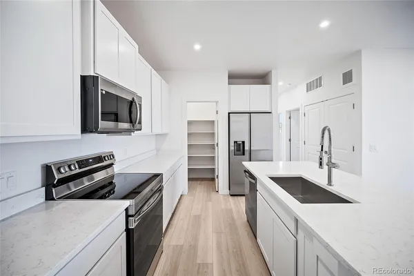 a kitchen with stainless steel appliances a sink stove and refrigerator