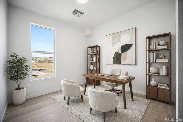 a view of a workspace with furniture and window in a room