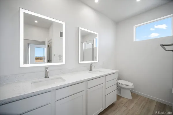 a bathroom with a double vanity sink toilet and a mirror