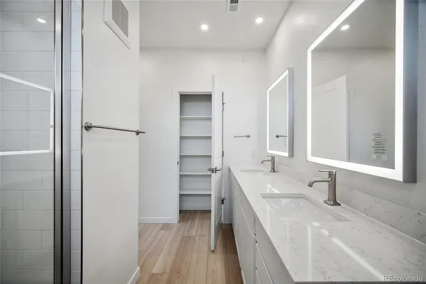 a bathroom with a double vanity sink a mirror and a bathtub