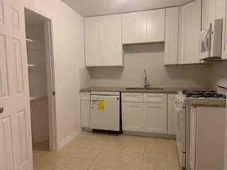 434 South 11th Street Aransas Pass, TX 78336 - Photo 6 of 16 a kitchen with white cabinets and white appliances