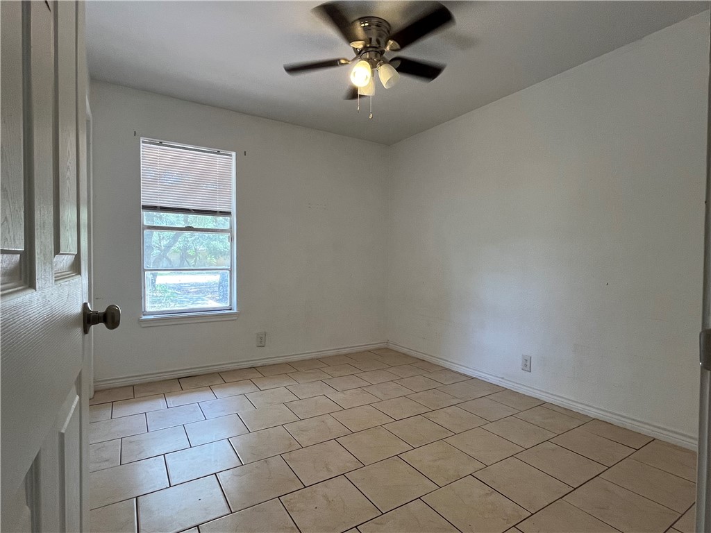 434 South 11th Street Aransas Pass, TX 78336 - Photo 10 of 16 wooden floor in an empty room with a window