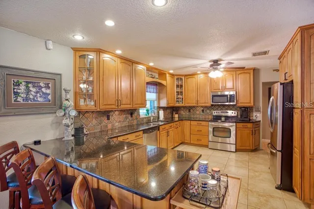 a kitchen with stainless steel appliances granite countertop a sink refrigerator and cabinets