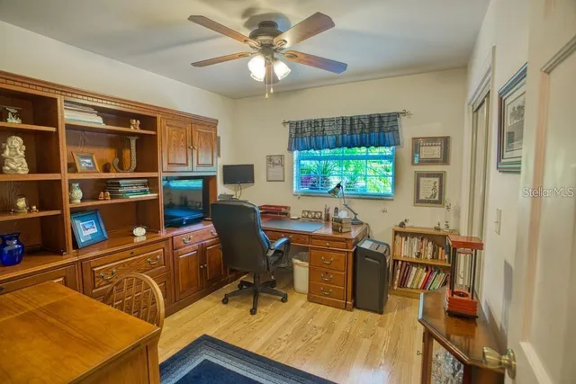 a view of a workspace with furniture and a window